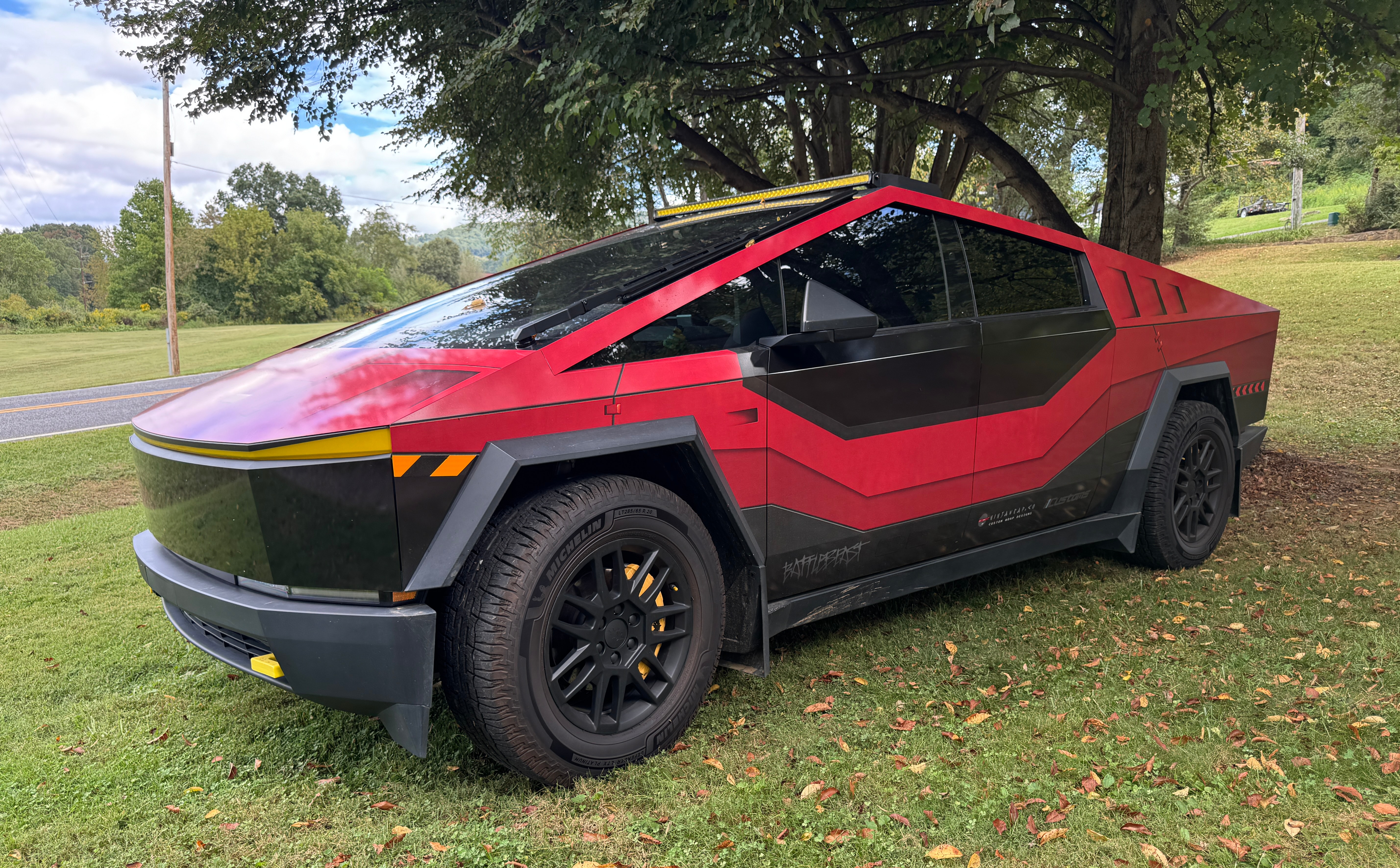 Red and black custom-wrapped 2024 Cybertruck Cyberbeast with off-road light bar